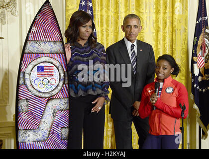 Washington, Distretto di Columbia, Stati Uniti d'America. 29Sep, 2016. American medaglia d oro-ginnasta vincente Simone Biles, destro presenta un autografo della tavola da surf al Presidente degli Stati Uniti Barack Obama, centro e la first lady Michelle Obama, sinistra, durante una cerimonia di accoglienza il 2016 noi Olimpici e Paralimpici squadre per la Sala Est della Casa Bianca a Washington DC a onorare la loro partecipazione e il successo in questo anno di giochi a Rio de Janeiro in Brasile.Credit: Ron Sachs/Piscina via CNP Credito: Ron Sachs/CNP/ZUMA filo/Alamy Live News Foto Stock