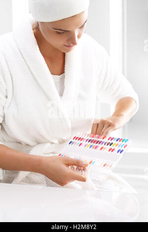 Cura delle mani nella spa salone. Tavolozza dei colori di smalti per unghie. La donna sceglie il colore dello smalto per unghie. Foto Stock