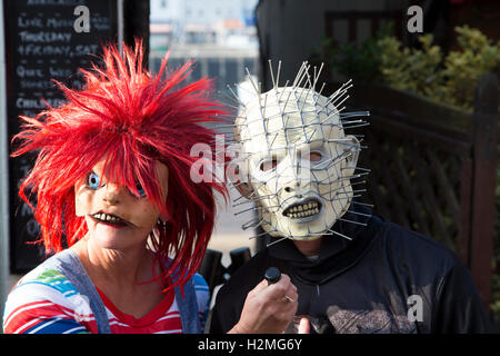 L uomo e la donna vestita di goth in maschere su Whitby goth weekend Foto Stock