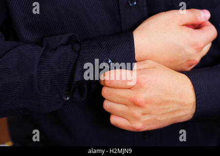 Closeup uomo braccio indossare tuta, regolazione gemelli usando le mani, gli uomini di vestirsi concept Foto Stock