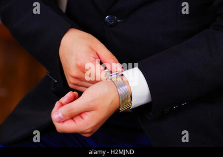 Closeup uomo braccio indossare tuta, argento di regolazione orologio al polso usando le mani, gli uomini di vestirsi concept Foto Stock