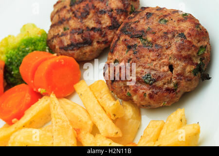 Bifteki greco con patate fritte e verdure Foto Stock