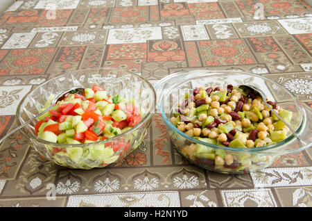 Ciotole di insalata mista con cetrioli e pomodori e uno con ceci, fagioli bianchi e i fagiolini verdi Foto Stock