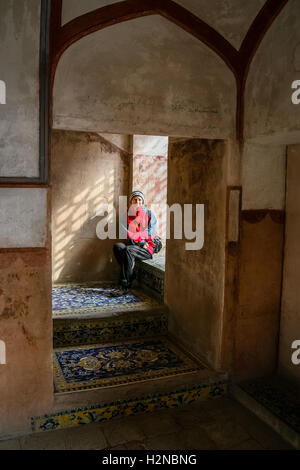 Tourist appoggiata dalla finestra all'interno della Sheikh Lotf Allah moschea di Elazig, Turchia Foto Stock