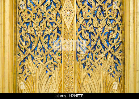 Close-up di intricati blu e oro che dettaglia la decorazione di un tempio buddista a Bangkok in Tailandia Foto Stock