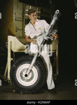 Worker che tiene la ruota anteriore e il dispositivo di atterraggio durante la produzione del bombardiere B-25, North American Aviation, Inc, Inglewood, California, USA, Alfred T. Palmer, USA Ufficio delle informazioni di guerra, ottobre 1942 Foto Stock