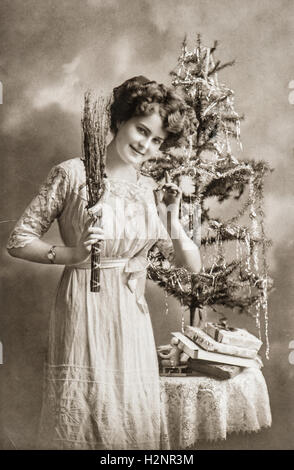 Giovane donna con albero di Natale e regali. Antique Picture con originale graffi e grana della pellicola Foto Stock