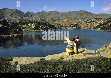 Donna e bambino che si affaccia sul lago, Massiccio del Carlit, dipartimento Pyrénées-Orientales, Regione Languedoc-Roussillon, Francia Foto Stock
