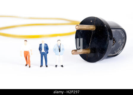 Uomo in miniatura sulla spina di alimentazione Foto Stock