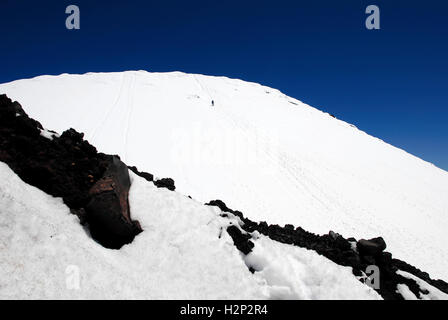 Un escursionista solitario ascende la coperta di neve vetta del Monte Ngauruhoe nel Parco Nazionale di Tongariro, Nuova Zelanda. Foto Stock