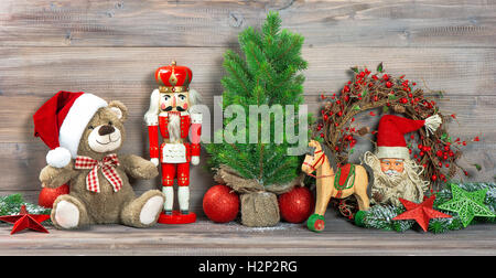 Decorazione di natale con giocattoli antichi orsacchiotto e schiaccianoci. Ornamenti di festa Foto Stock