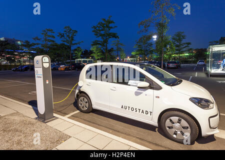 Auto elettrica Volkswagen eUP! In corrispondenza di una colonna di carica in Autostadt Wolfsburg, Germania Foto Stock