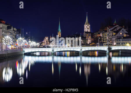 Vista notturna della Limmat, con la Basilica di San Pietro e Fraumunster chiese, a Zurigo, Svizzera Foto Stock