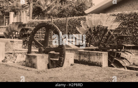 Vecchie ruote di un mulino ad acqua. In stile vintage foto. Aggiunta di grano per dare una vecchia foto effetto. Foto Stock