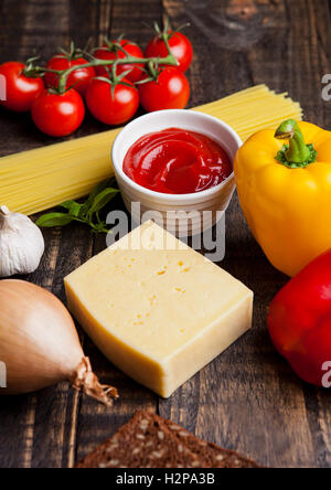 Cibo crudo mix spaghetti pomodoro il formaggio e il pane sulla tavola di legno Foto Stock