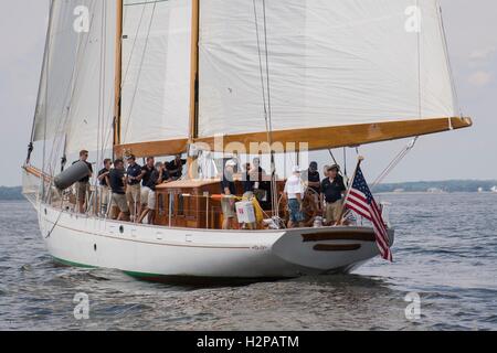 Il cantante Jimmy Buffett (camicia bianca), cerca la sua mano al timone dell'U.S. Naval Academy Formazione barca a vela Summerwind al fianco di skipper James Maitland, a destra sulla baia di Chesapeake Settembre 8, 2016 in Annapolis, Maryland. Buffett aderito all'Accademia Navale di fondazione di vela per il giorno della vela sul Summerwind e l'America. Foto Stock