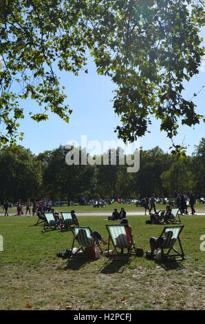 La folla godendo una giornata di sole nel parco verde, Londra, Inghilterra. Foto Stock