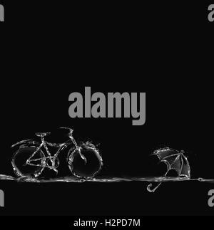 Una bicicletta fatta di acqua per rappresentare eco-friendly il trasporto con un ombrello flottante. Foto Stock