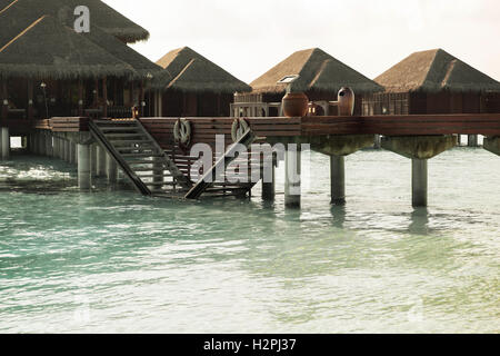 Bungalow capanne in acqua di mare esotici sulla spiaggia del resort Foto Stock