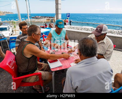 Cinque uomini godono di un gioco di carte da mare presso il villaggio di Paul do Mar Foto Stock