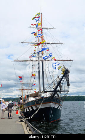 Un grande albero mast tall ship sotto il cielo blu nel porto di Hamilton, Ontario, Canada, i visitatori di andare sulla nave. Foto Stock