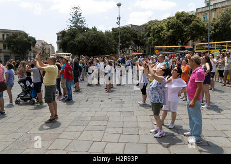 I turisti in attesa di fotografare il campanile orologio in Messina Italia Foto Stock