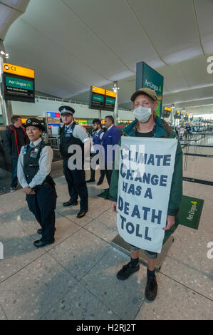 Aeroporto di Heathrow di Londra, Regno Unito. 1 ottobre 2016. Come parte di un'ondata globale di resistenza all'aeroporto espansione su ambiente e motivi sociali, diverse centinaia di manifestanti stadio un flash mob protesta all'interno del Terminal 2 di Heathrow, inizio con una matrice, con 'frequenti volantini a scavalcare i loro corpi morti e bagagli per un champagne fast track check-in desk, seguito da canti e balli. Cooperazione di polizia e di sicurezza si fermò e guardato e non intervenire. con la protesta pacifica. #StayGrounded protesta fu organizzata da rivendicare il potere, che ha anche messo in scena una 'red' linea di protesta da parte di ciclisti in aeroporto a Foto Stock