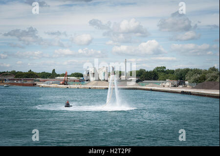 Un flyboarder è spinta in aria da un getto di acqua ad alta pressione da un getto sci mentre utilizzando un flyboard sul fiume arun, littlehampton, Inghilterra. Foto Stock