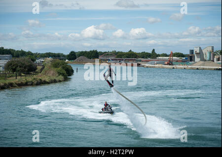 Un flyboarder è spinta in aria da un getto di acqua ad alta pressione da un getto sci mentre utilizzando un flyboard sul fiume arun, littlehampton, Inghilterra. Foto Stock