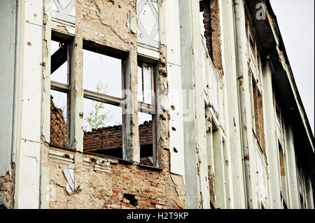 Tracce di proiettili su una facciata di edificio distrutto dalla guerra Foto Stock