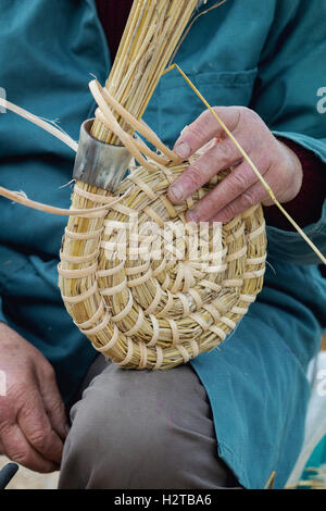 L'uomo / apicoltore facendo un tradizionale bee skep in corrispondenza Dalyseford mostra d'autunno. Inghilterra Foto Stock