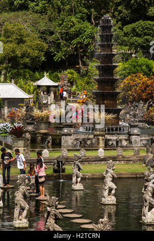 Indonesia, Bali, Tirta Gangga, Ababi, Palace, turisti in acqua giardino alla piscina pietre miliari Foto Stock