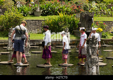 Indonesia, Bali, Tirta Gangga, Ababi, Palace, turismo locale indossando il costume tradizionale in acqua piscina garden Foto Stock