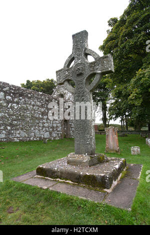 Isola di Islay, Scozia. Il Kildalton alta croce, con la ex chiesa parrocchiale di Kildalton in background. Foto Stock