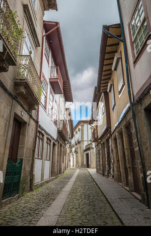 Guimaraes, Portogallo - 28 Aprile 2014: facciate di edifici medievali e vicolo vicino alla piazza di Santiago, noto anche come Sao Thiag Foto Stock