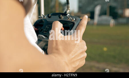 Mani tenendo un trasmettitore controllo FPV drone Foto Stock