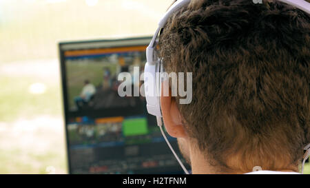 La trasmissione video editor con le cuffie a schermo Foto Stock
