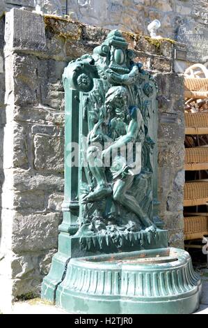 Fontana al di fuori di bronzo con una statua di Zeus tenendo un pesce. Foto Stock