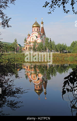 Chiesa russa ortodossa conosciuta come chiesa di esaltazione della Santa Croce e la sua riflessione in Almaty, Kazakhstan Foto Stock