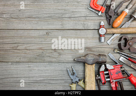 Raccolta di vari vecchi utensili a mano comprendente una pinza martello chiavi dinamometriche e pinza sul tavolo di legno sfondo Foto Stock