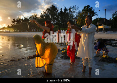 Ganga Snan (Asnan) Indù, festival, famiglie indù rendendo puja su Belle Mare spiaggia, isola Maurizio. Foto Stock