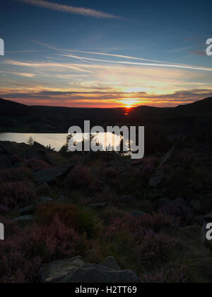 Dovestone serbatoio con il tramonto Wharmton e heather da sotto grande colomba rocce di pietra Greenfield Foto Stock