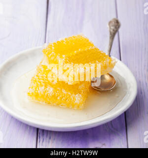 Il miele, favi su una lavanda di sfondo di legno Foto Stock