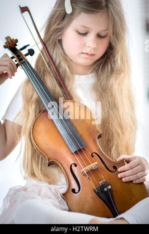 Ragazza con lunghi capelli biondi giocando con violino Foto Stock