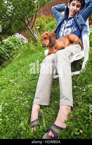 Ragazzo con un cane in giardino Foto Stock