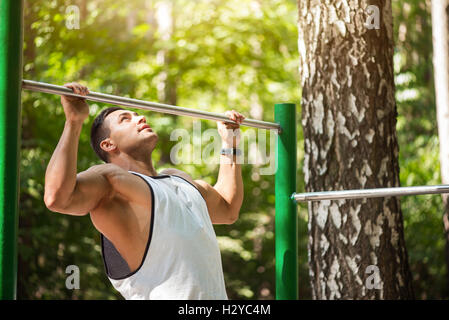 Piacevole di lavoro duro uomo facendo chin ups Foto Stock