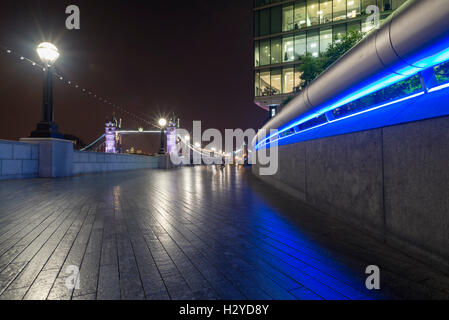 Vista notturna del Tower Bridge dal fiume illuminato Thames promenade di più di Londra area Riverside, Southwark, Londra,UK Foto Stock