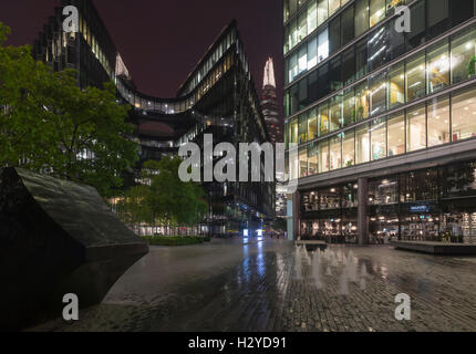 Vista notturna della più Londra riverside con artwork, fontane, facciate, edifici per uffici e il grattacielo Shard, Southwark, Londra Foto Stock