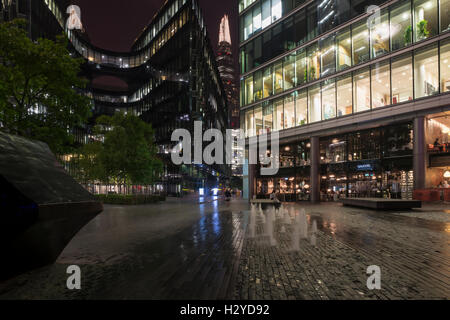 Vista notturna della più Londra riverside con artwork, fontane, facciate, edifici per uffici e il grattacielo Shard, Southwark, Londra Foto Stock