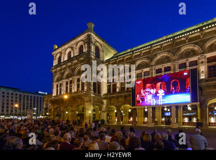 Wien, Vienna: Staatsoper , persone guardano il trasferimento delle attuali prestazioni dell'opera su uno schermo di grandi dimensioni nella parte anteriore del Foto Stock